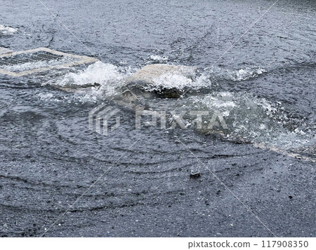 Rainwater overflowing from a gutter due to heavy rain 117908350
