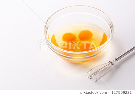 Eggs in a glass bowl and a whisk Eggs in a glass bowl and a whisk 117909221