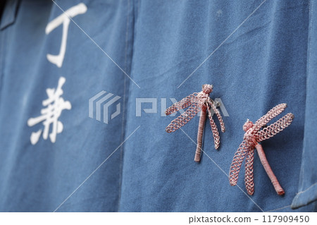 Scenery of an old post town. Handmade dragonfly folk crafts displayed on a shop curtain. 117909450