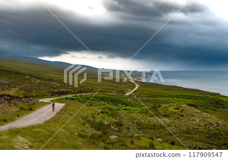 Rural Road With Cyclist At The Atlantic Coast Near Villages Cuaig And Kalnakill In Scotland, UK 117909547