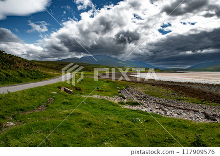 Abandoned Single Lane Road With Small Cottage And Mountains At Kyle Of Durness At The Atlantic Coast Of Scotland, UK Abandoned Single Lane Road With Small Cottage And Mountains At Kyle Of Durness At The Atlantic Coast Of Scotland, UK 117909576