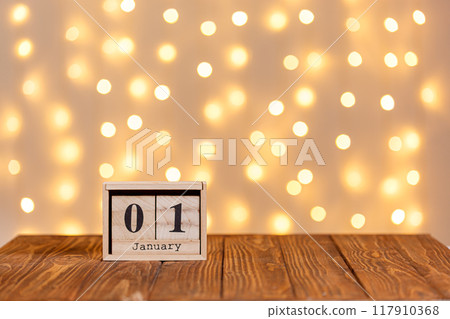 new year, wooden calendar january 1 on wooden background and lights background 117910368