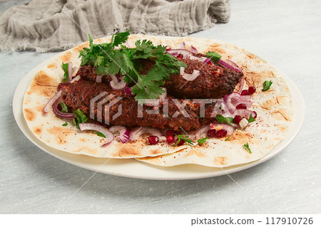 Lula kebab, on lavash, with red onion, pomegranate, and sumac, top view, close-up, horizontal, no people, Lula kebab, on lavash, with red onion, pomegranate, and sumac, top view, close-up, horizontal, no people, 117910726