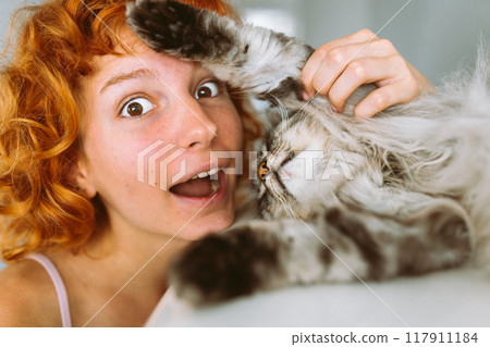 portrait red-haired teenage girl with gray fluffy cat portrait red-haired teenage girl with gray fluffy cat 117911184