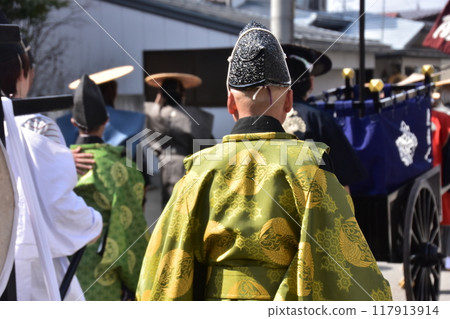 Takayama Festival in Spring, Takayama City, Gifu Prefecture, Japan. People participating in the Daimyo Procession. A man wearing a kimono and an old-fashioned hat. Takayama Festival in Spring, Takayama City, Gifu Prefecture, Japan. People participating in the Daimyo Procession. A man wearing a kimono and an old-fashioned hat. 117913914