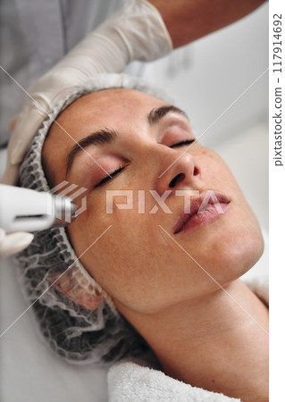 Woman receiving facial treatment in a spa during daytime Woman receiving facial treatment in a spa during daytime 117914692