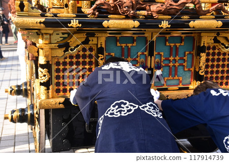 日本岐阜縣高山市春季高山節 — 男人們抬著豪華花車,穿著法衣,努力工作。 日本岐阜縣高山市春季高山節 — 男人們抬著豪華花車,穿著法衣,努力工作。 117914739