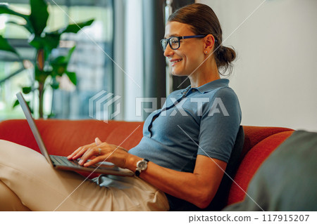 A Professional Woman Working Diligently on a Laptop in a Modern Office Setting Environment A Professional Woman Working Diligently on a Laptop in a Modern Office Setting Environment 117915207
