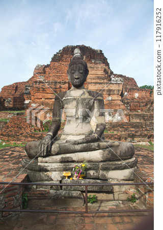 Ancient sandstone sculpture of Buddha at Wat Mahathat ruins is considered a very important temple is Unesco World Heritage Site in Ayutthaya Historical Park in Thailand. 117916252