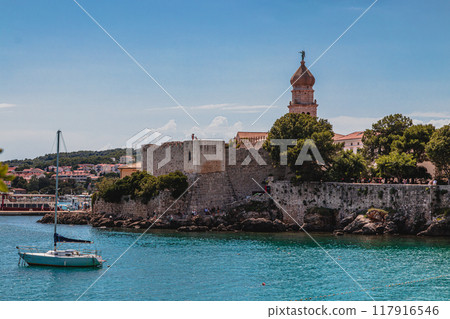 Krk Croatia 26.06.24 Boats on little port beside old town view with vegetation Krk Croatia 26.06.24 Boats on little port beside old town view with vegetation 117916546
