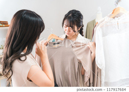 一位女士在服飾店買衣服，一位店員（不滿意、不喜歡、不適合她） 117917684