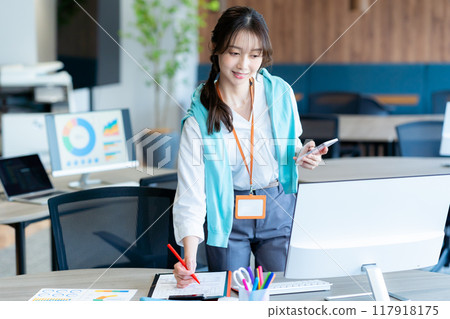 有一部智能手機的女商人在辦公室 117918175