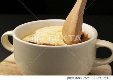 Onion gratin soup lifted with spoon 117919612