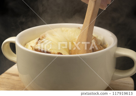 Onion gratin soup lifted with spoon 117919613