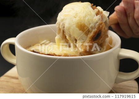 Onion gratin soup lifted with spoon Onion gratin soup lifted with spoon 117919615
