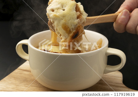 Onion gratin soup lifted with spoon 117919619