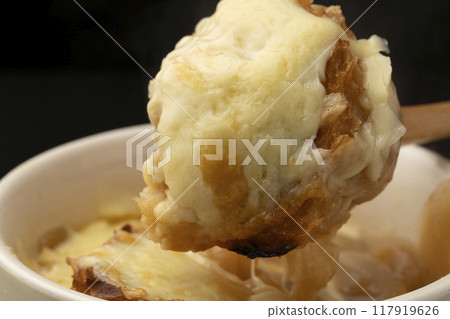 Onion gratin soup lifted with spoon 117919626