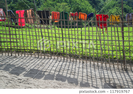 A bamboo fence with clothes hanging to dry in the sun. and agricultural plots The way to the village of the Moon tribe, Mindat, Chin State, Myanmar. 117919767