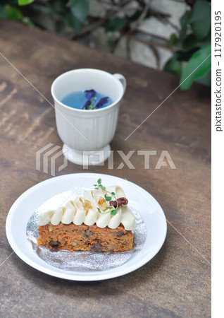 carrot cake with cream and walnut topping , carrot cake and butterfly pea tea 117920195