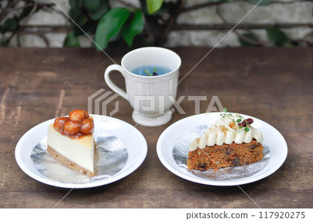carrot cake with cream and walnut topping ,caramel macadamia cheesecake and butterfly pea tea 117920275