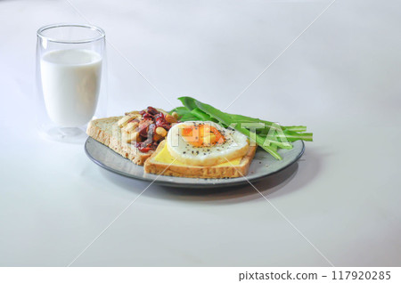 bread with egg and cheese topping or  sunny side up egg , lettuce and almond with dried cranberry and milk 117920285