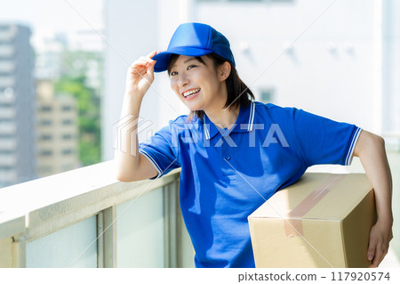 Courier female driver delivering luggage 117920574