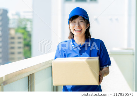 Courier female driver delivering luggage 117920575