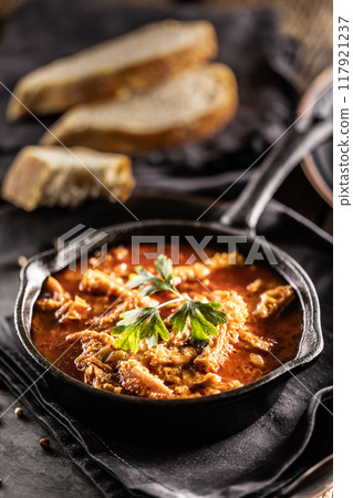 Tasty soup or stew made of beef tripe and spices. Spicy and aromatic tripe soup seasoned with pepper and served with bread 117921237