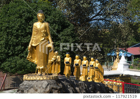 Beautiful statues of Buddha and monks holding alms bowls line up at Mahamuni Phya temple. It is located on the Rakhine State, Myanmar. Beautiful statues of Buddha and monks holding alms bowls line up at Mahamuni Phya temple. It is located on the Rakhine State, Myanmar. 117921519