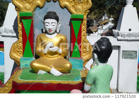 An outdoor statue of a Burmese Buddhist woman paying homage to Buddha adorns front of the chapel or Buddhist church at Wat Mahamuni Phraya temple. It is located on the Rakhine State, Myanmar. An outdoor statue of a Burmese Buddhist woman paying homage to Buddha adorns front of the chapel or Buddhist church at Wat Mahamuni Phraya temple. It is located on the Rakhine State, Myanmar. 117921520