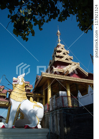 A white lion statue adorns the front of the chapel or Buddhist church at Wat Mahamuni Phraya temple. It is located on the Rakhine State. Myanmar. A white lion statue adorns the front of the chapel or Buddhist church at Wat Mahamuni Phraya temple. It is located on the Rakhine State. Myanmar. 117921524