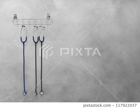 Stethoscope hanging on cement background Stethoscope hanging on cement background 117922037