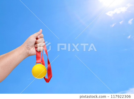 Holding a gold medal, winner, sky background 117922306