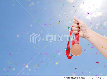 holding a bronze coin celebrate success sky background 117922312