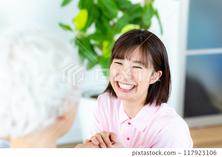 Caregiver supporting a woman in a wheelchair 117923106