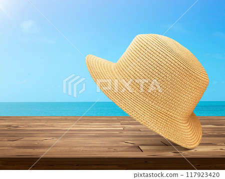 Straw hat laying on wooden table with sky and sea background. Straw hat laying on wooden table with sky and sea background. 117923420