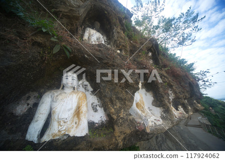 Akauk Taung has a Buddha image carved in sandstone on the Akauk Mountain cliff along the Ayeyavadee River near Htonbo village. Magway Region.Myanmar. 117924062