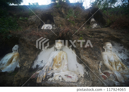 Akauk Taung has a Buddha image carved in sandstone on the Akauk Mountain cliff along the Ayeyavadee River near Htonbo village. Magway Region.Myanmar. 117924065