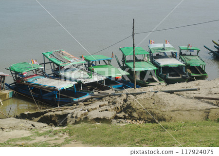 Tourist boats are waiting for tourists at Pai Akktong pier. There is a Buddha image carved from sandstone on Akak mountain near Thanbo Village at Magway Region.Myanmar. 117924075