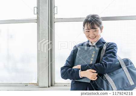 Smiling high school students, junior high school students, high school girls (graduation ceremony, uniform, school uniform) with diplomas and certificate files in school classrooms 117924218