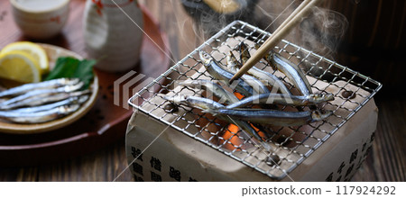 Grilling dried silver-striped round herring 117924292