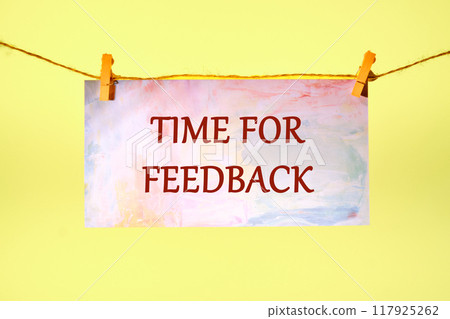 Conceptual time for feedback symbol. Copy space. TIME FOR FEEDBACK words written on a piece of paper in a clothespin on a rope on a yellow background 117925262