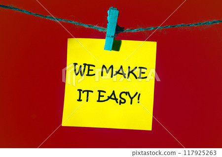 Business motivational we make it easy concept. Copy space. Concept words WE MAKE IT EASY on a yellow sticker on a red background 117925263