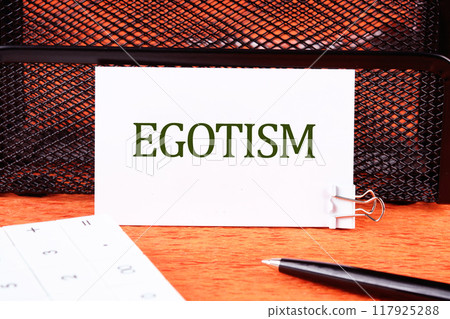 Concept image. the word EGOTISM on a white business card close-up 117925288