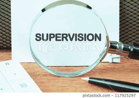 The word supervision. concept of supervision. the action, process, or occupation of supervising. SUPERVISION on a white sheet through a magnifying glass, close-up The word supervision. concept of supervision. the action, process, or occupation of supervising. SUPERVISION on a white sheet through a magnifying glass, close-up 117925297