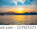 Kobe Bridge and luxury cruise ship illuminated by the setting sun 117925373