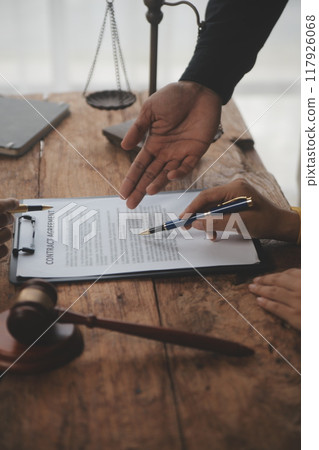 Business and lawyers discussing contract papers with brass scale on desk in office. Law, legal services, advice, justice and law concept picture with film grain effect 117926068