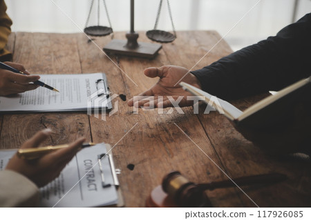 Business and lawyers discussing contract papers with brass scale on desk in office. Law, legal services, advice, justice and law concept picture with film grain effect 117926085