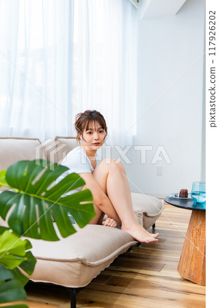 Woman in loungewear relaxing on sofa / Holiday morning / Relaxing Woman in loungewear relaxing on sofa / Holiday morning / Relaxing 117926202