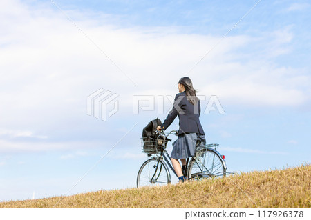 High school girl cycling to school High school girl cycling to school 117926378